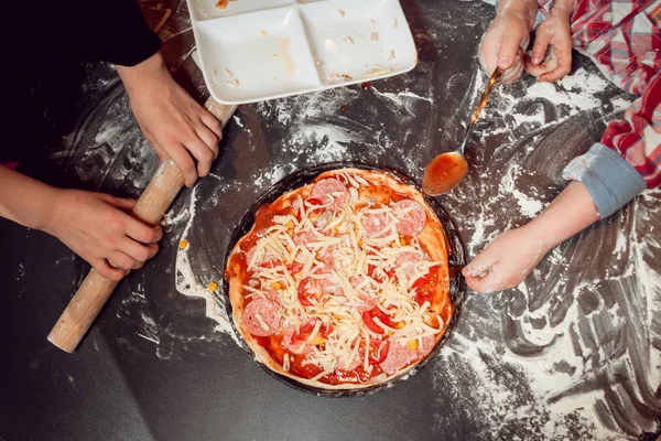 The process of making pizza. Children make pizza at home.