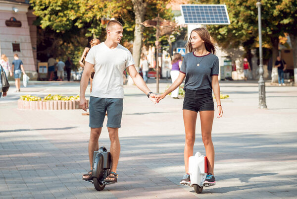 Молодая кавказская пара едет по сегментам через город
