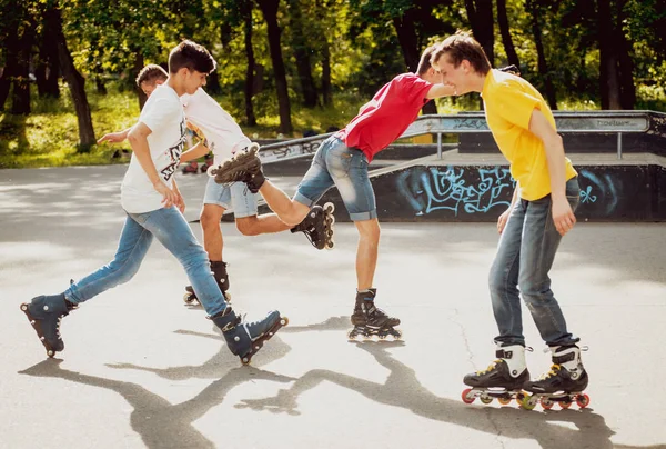 Четыре Молодых Роллера Практикующих Скейтпарке — стоковое фото