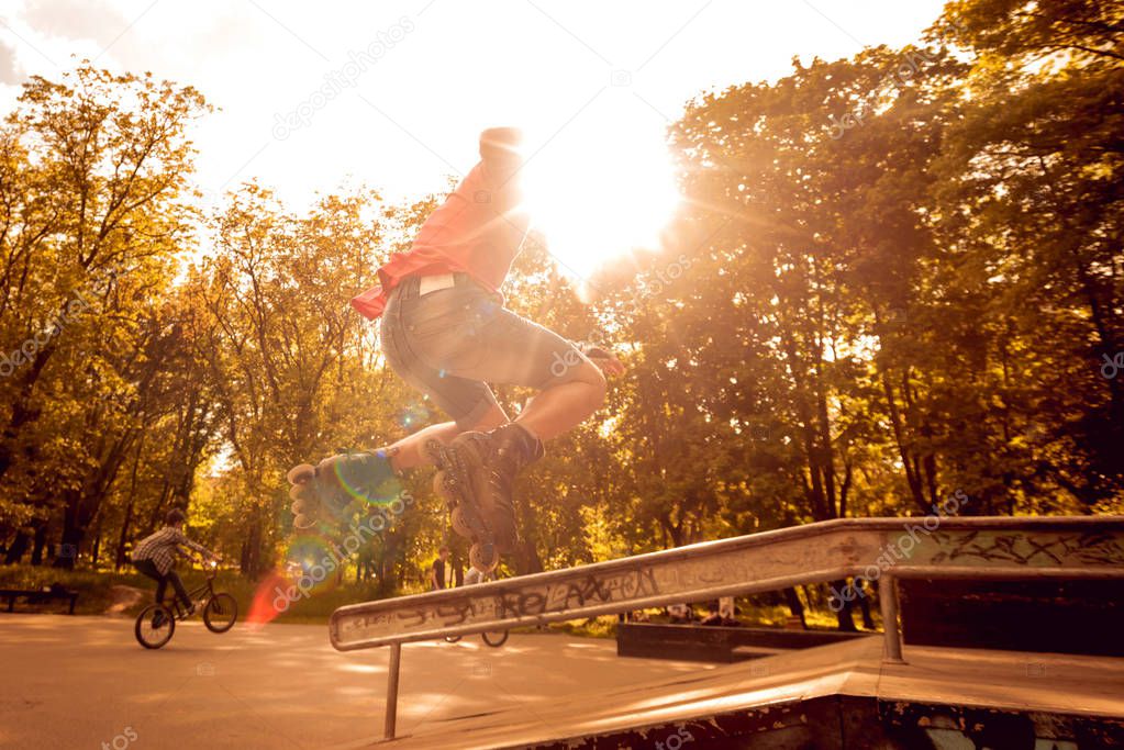 Young roller doing tricks in skatepark