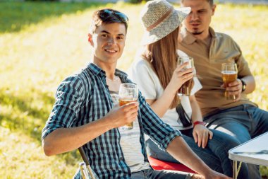 Parkta piknik neşeli Beyaz arkadaşlar. Gülümseyen ve söz.
