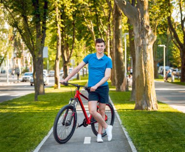 Mutlu genç beyaz adam Yeşil Bisiklet şeritli üzerinde Bisiklete binme