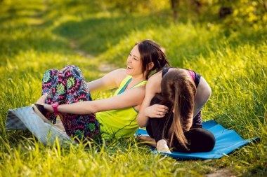 İki genç kız parkta Yoga uygulamak ve having fun
