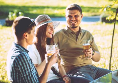 Parkta piknik neşeli Beyaz arkadaşlar. Gülümseyen ve söz.