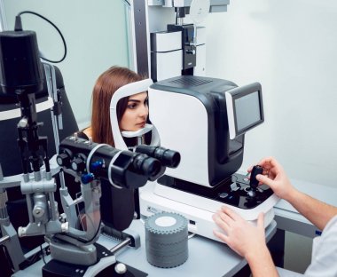 Genç kadın görüşünü göz doktoru ile kontrol. Tıbbi donatımı.