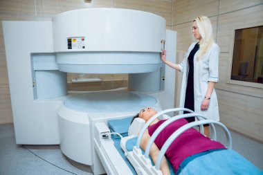Bayan Beyaz doktor ve femele Orta Doğu hasta hastane MRI odasında.