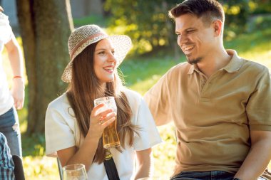 Parkta piknik neşeli Beyaz arkadaşlar. Gülümseyen ve söz.