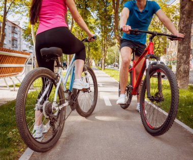 Genç çift yeşil Bisiklet lane güneşli bir günde Bisiklete binme