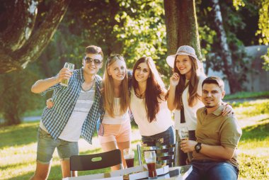 Parkta piknik neşeli arkadaşlar. Gülümseyen ve söz.