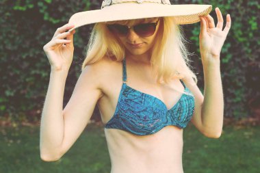 Genç kız mavi mayo yeşil çimenlerin üzerinde rahatlatıcı.