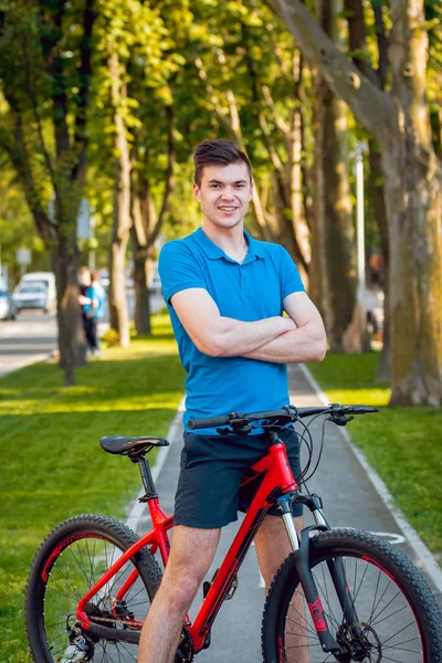 Mutlu genç beyaz adam Yeşil Bisiklet şeritli üzerinde Bisiklete binme