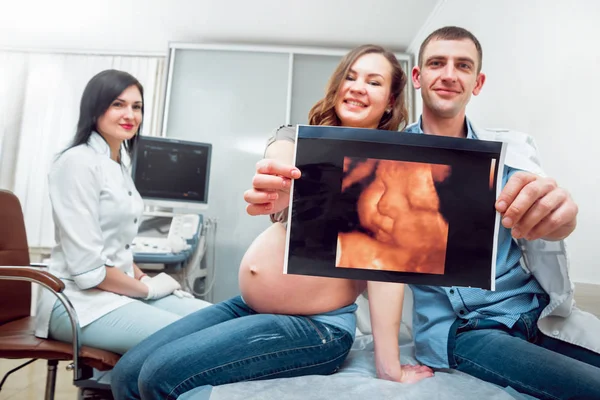 女医生和年轻孕妇与丈夫的病人 超声波设备 — 图库照片