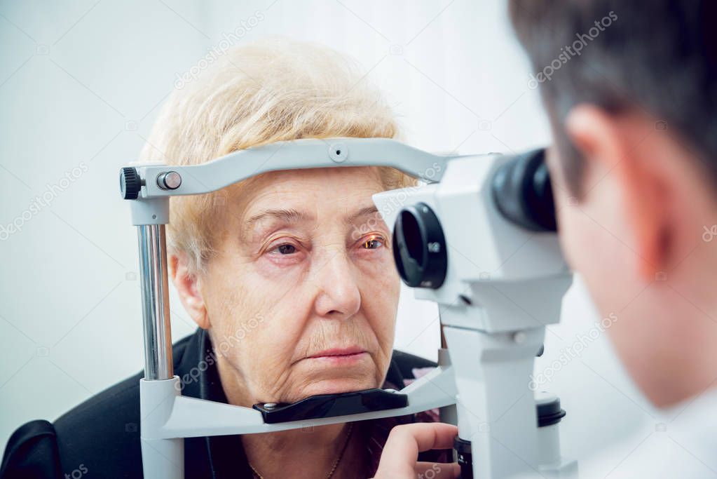Senior woman checking her vision with ophthalmologist. Medical equipment. Coreometry.