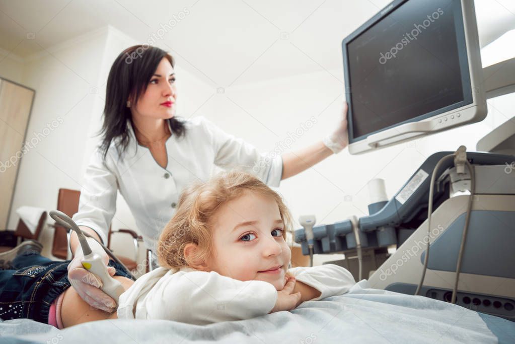 Female doctor and little blonde girl patient. Ultrasound equipment. Diagnostics. Sonography.