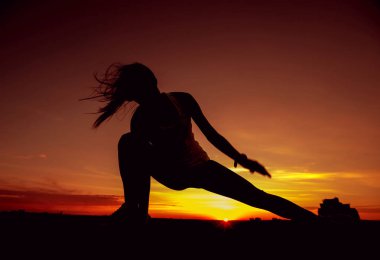 Genç kız yoga çatıda. Siluet