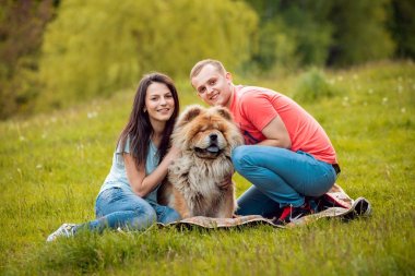 Parkta yürüyüş ve iyi vakit geçiriyorlardı onların köpek uyumak ile genç Çift