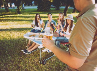 Parkta piknik neşeli arkadaşlar. Gülümseyen ve söz.