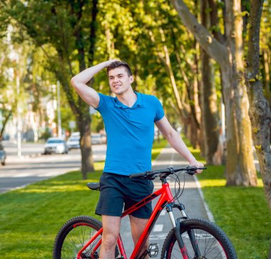 Mutlu genç beyaz adam Yeşil Bisiklet şeritli üzerinde Bisiklete binme