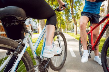 Genç çift yeşil Bisiklet lane güneşli bir günde Bisiklete binme