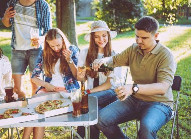 Parkta piknik neşeli arkadaşlar. Gülümseyen ve söz.