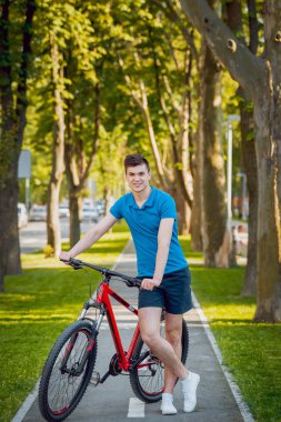 Mutlu genç beyaz adam Yeşil Bisiklet şeritli üzerinde Bisiklete binme