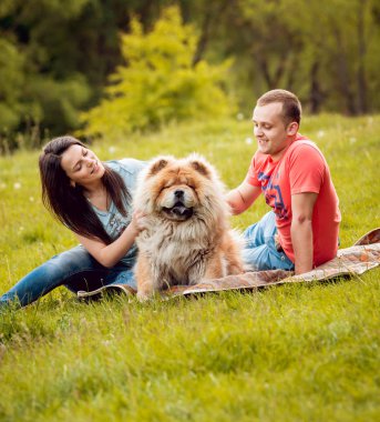 Parkta yürüyüş ve iyi vakit geçiriyorlardı onların köpek uyumak ile genç Çift