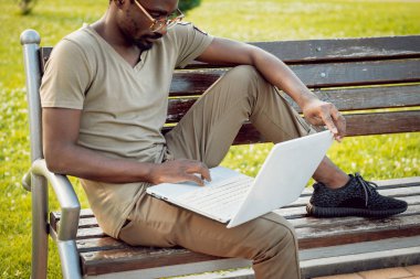 Afrika delikanlı şapka ve gözlük yeşil Şehir Parkı içinde laptop ile