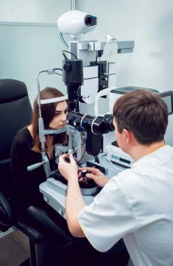 Genç kadın görüşünü göz doktoru ile kontrol. Tıbbi donatımı.