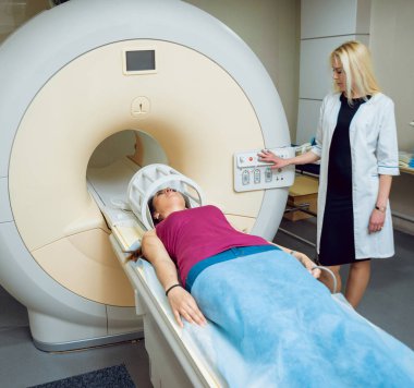 Bayan Beyaz doktor ve femele Orta Doğu hasta hastane MRI odasında.