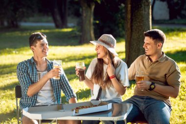 Parkta piknik neşeli Beyaz arkadaşlar. Gülümseyen ve söz.