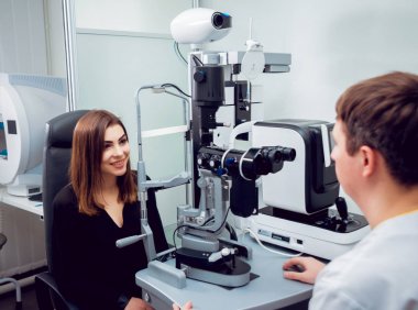 Genç kadın görüşünü göz doktoru ile kontrol. Tıbbi donatımı.