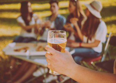 Parkta piknik neşeli arkadaşlar. Bira içmek