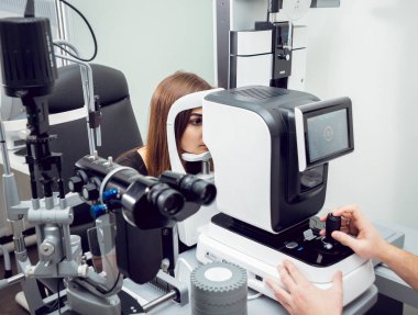 Genç kadın görüşünü göz doktoru ile kontrol. Tıbbi donatımı.