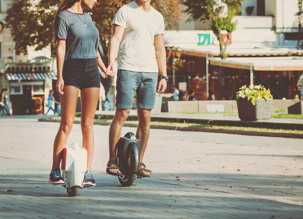 Молодая кавказская пара катается на сегвеях в парке
.