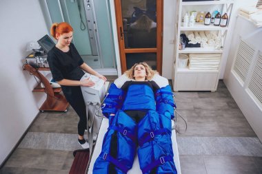 Pressotherapy Güzellik Merkezi kadında makinede. Kozmetik tıp cihazları