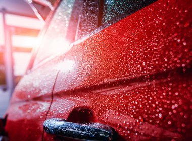 Elektrikli otomobil ayrıntıları. Kapı kolu ve yağmur damlaları. Kırmızı renk