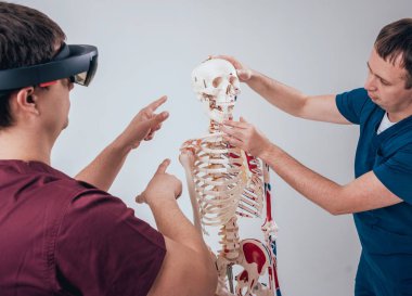 Doktor kullanır augmented gerçeklik gözlükleri ve öğrenci öğretim insan iskeleti