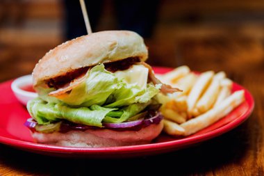 Büyük çizburger ve patates kızartması bir plaka üzerinde. Restoran