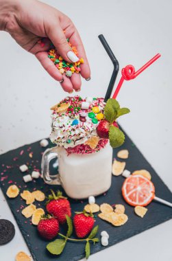 İle sprinkles, çilekli milkshake bardak çırpılmış krema ve taze çilek