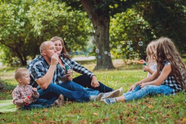Büyük genç aile parkta iyi vakit geçiriyor.