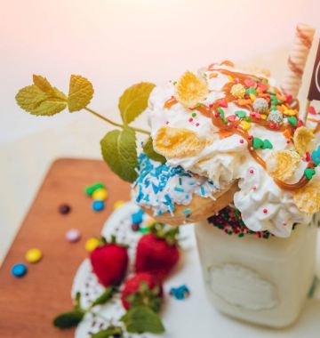 İle sprinkles, çilekli milkshake bardak çırpılmış krema ve taze çilek