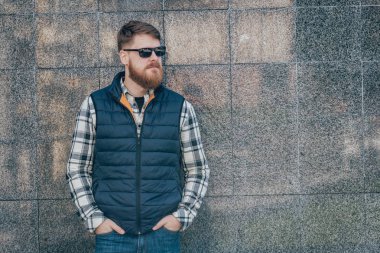 Yakışıklı adam açık havada kameraya poz rahat kıyafetler içinde sakallı