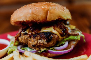 Büyük çizburger ve patates kızartması bir plaka üzerinde. Restoran