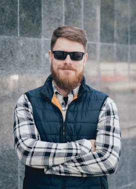 Yakışıklı adam açık havada kameraya poz rahat kıyafetler içinde sakallı