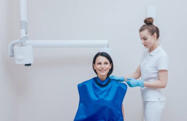 Diş hekimi diş kliniğinde genç kadın için x-ray görüntü olun. Diş Radyografi hedefleyen.