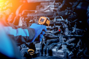 Kızılötesi Lazer termometre elinde. Araba Servisi motor sıcaklık ölçüm