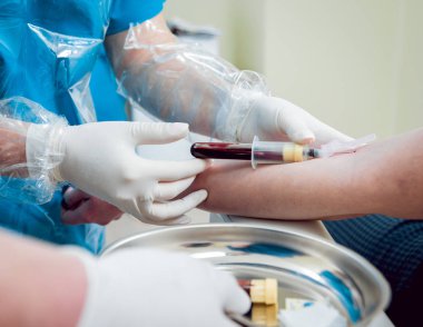 Hemşirenin ellerinden kan örneği alırken..