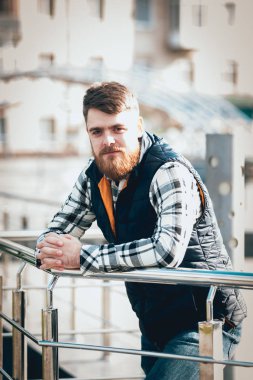 Yakışıklı adam açık havada kameraya poz rahat kıyafetler içinde sakallı