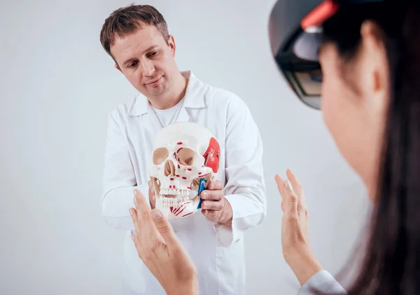 医生使用增强现实护目镜和人类 Skullfor 教学学生 — 图库照片