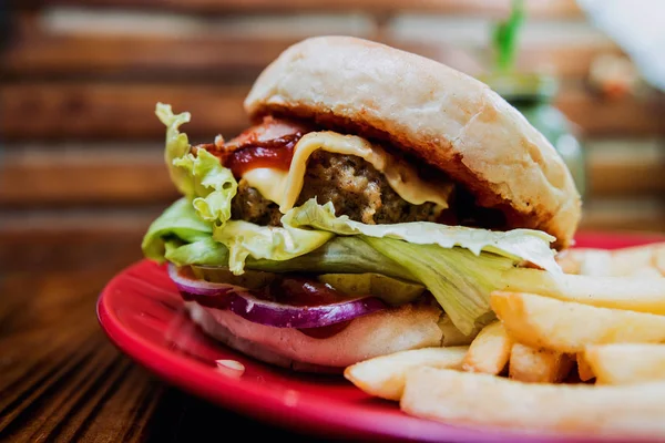 Büyük çizburger ve patates kızartması bir plaka üzerinde. Restoran